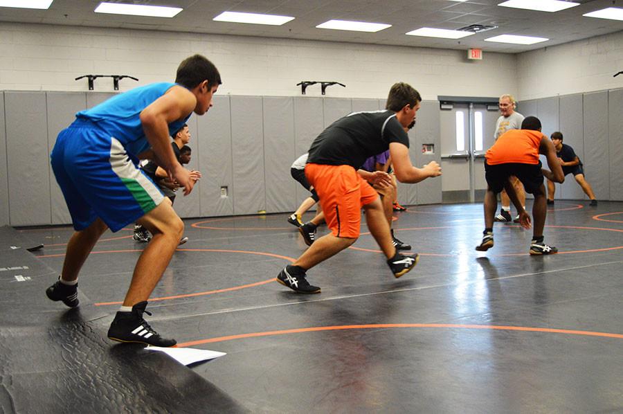 During practice, the boys wresting team goes through extensive warm-ups, preparing themselves for a competitive season.