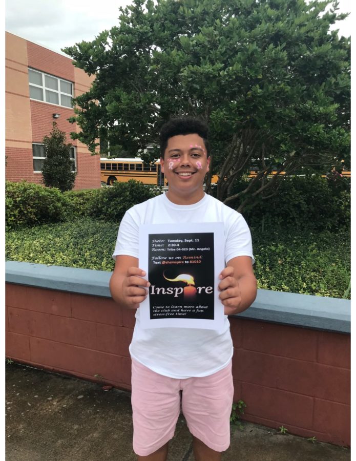 Senior Miguel Garzon holds up a flyer for his school positivity club, Inspire. 