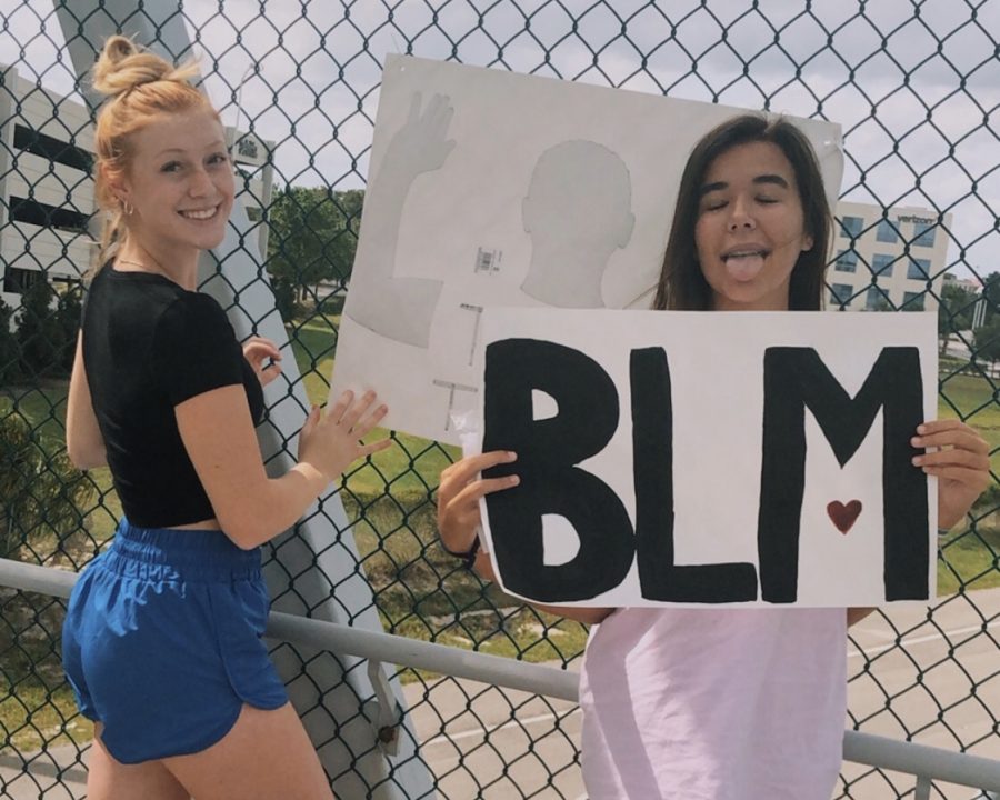 The year 2020 has involved some life changing events, an important one being the Black Lives Matter Movement. In this picture you see seniors Payton Whitney and Maddie Cannon with posters they made as they hang them over the city of Lake Mary. They did this to show their support and spread awareness to the movement as many other people are doing, whether through protests, donating, and or making signs like shown. 
