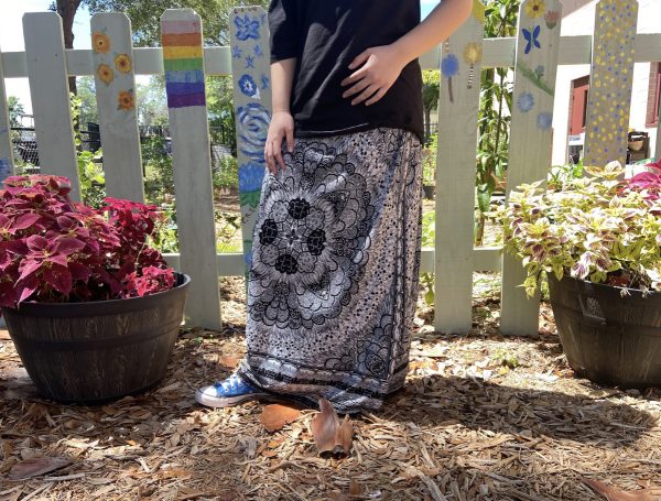 Seminole High Student pictured in her anticipated summer wear- a long and unique patterned skirt along with a classic blue converse and black tee. 
